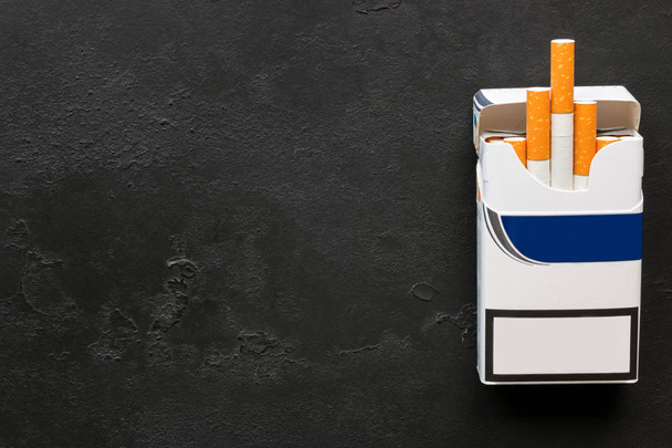 A pack of cigarettes on a black background with space for text - Fotoğraf, Görsel