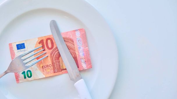 Euro banknote on a white plate, cash in Europe, the cost of lunch in the restaurant - Photo, Image