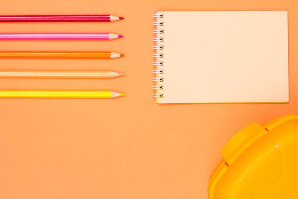 Color pencils, notebook and lunch box on pink background. Top view with copy space. Back to school concept. School supplies. Pastel colors - Photo, image