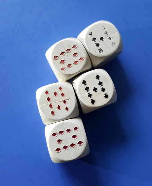 witte dobbelstenen met speelkaarten symbolen op ble achtergrond, afbeelding - Foto, afbeelding