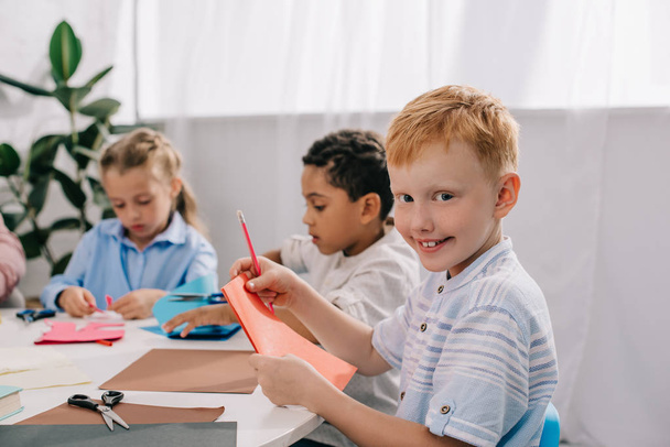 entzückende multikulturelle Kinder basteln Papierapplikationen im Klassenzimmer - Foto, Bild