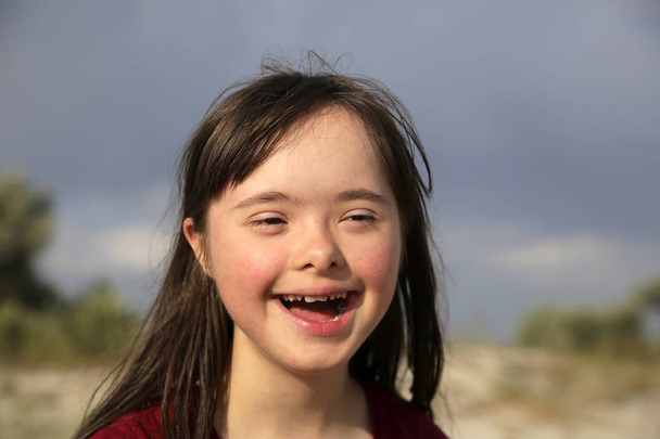 Портрет девушки с синдромом Дауна, улыбающейся - Фото, изображение