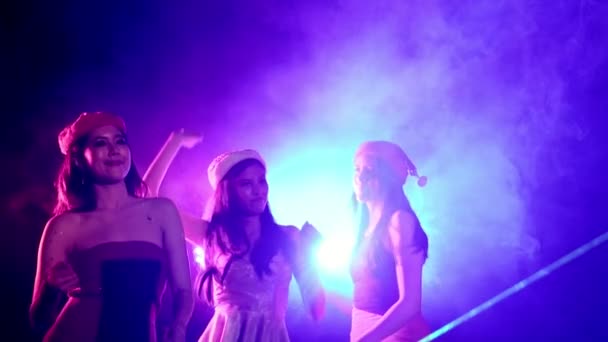 Grupo multiétnico de hermosas mujeres bailando, animando música de fiesta con amigos en la pista de baile de un club nocturno con luces y humo en el fondo. Tiro medio, cámara lenta
. - Metraje, vídeo