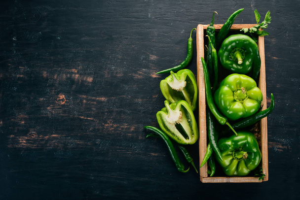 Fresh green pepper and chili pepper in a wooden box. Top view. Free space for text. - Foto, immagini