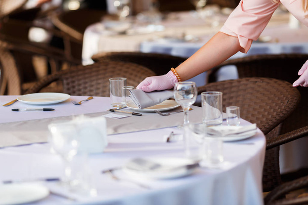 Glasses, forks, knives, plates on a table in restaurant served for dinner - Fotoğraf, Görsel