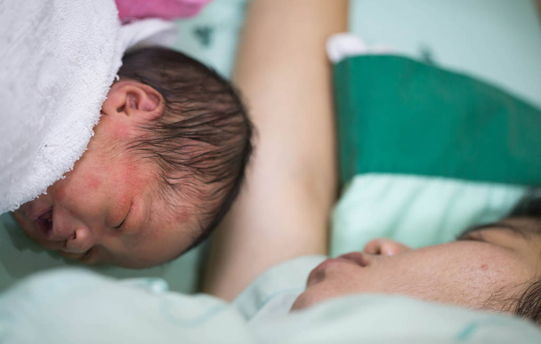 I neonati dormono su un letto paziente con una madre
. - Foto, immagini