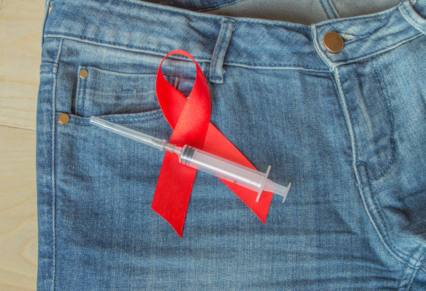 awareness AIDS red ribbon on jeans, a symbol of opposition - Photo, Image