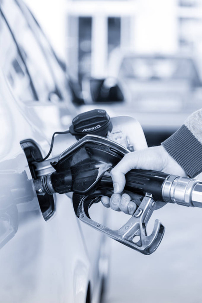 Closeup of mans hand pumping gasoline fuel in car at gas station. - Photo, Image