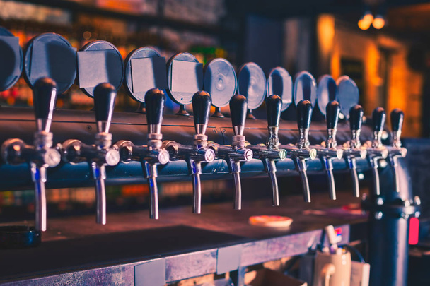 Beer taps in beer bar. Beer tap array. - Fotografie, Obrázek