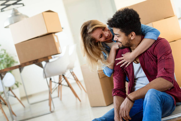 Young couple in love unpacking cardboard boxes at new home moving in concept - Foto, immagini