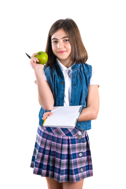 μαθήτρια με το σημειωματάριο και μήλο σε λευκό φόντο. - Φωτογραφία, εικόνα