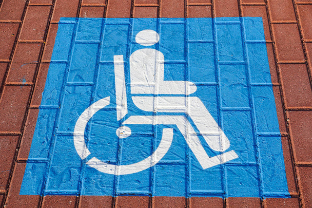 Σύμβολο στάθμευσης για τα άτομα με αναπηρία στο χώρο στάθμευσης αυτοκινήτων επιλεκτική εστίαση . - Φωτογραφία, εικόνα