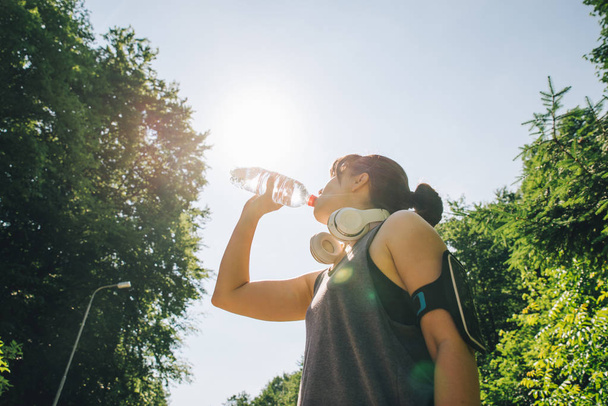 ランナー女性は、夏の暑い日に水を飲む。コピー スペース - 写真・画像