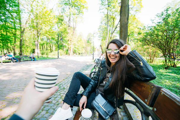 コーヒーを飲みながらベンチに座っているカップル。ライフ スタイルのコンセプト - 写真・画像