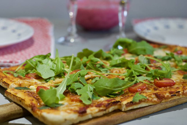 Fresh and tasty vegetarian homemade pizza with tomatoes and rucola. - Zdjęcie, obraz