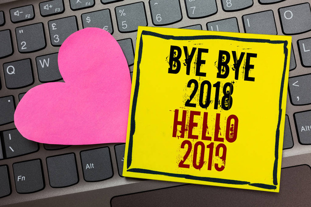 A kézírás szöveg írása Bye Bye 2018 Hello 2019. Koncepció, ami azt jelenti, kezdő Szilveszter motivációs üzenet 2018 írta át a fekete keretes sárga oldal megérintette a számítógép billentyűzet rózsaszín szív - Fotó, kép