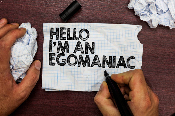 Conceptual hand writing showing Hello I am An Egomaniac. Business photo text Selfish Egocentric Narcissist Self-centered Ego Hand hold pen sketch word on torn page woody deck hand paper ball - Photo, Image