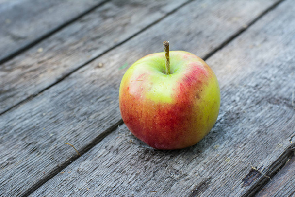 reifer roter und gelber Apfel auf Holztisch. Apfel im Garten. vegetarisches Konzept. Herbsternte. Stillleben. - Foto, Bild