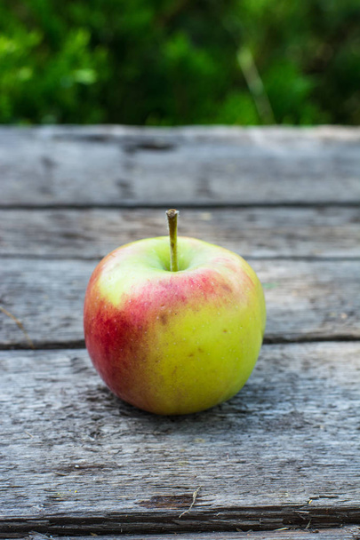 木製のテーブルに熟した赤と黄色リンゴ。庭のリンゴ。ベジタリアンのコンセプトです。秋の収穫。静物食品. - 写真・画像