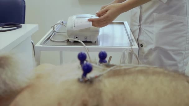 Senior man make electrocardiography in cardiologist - Záběry, video