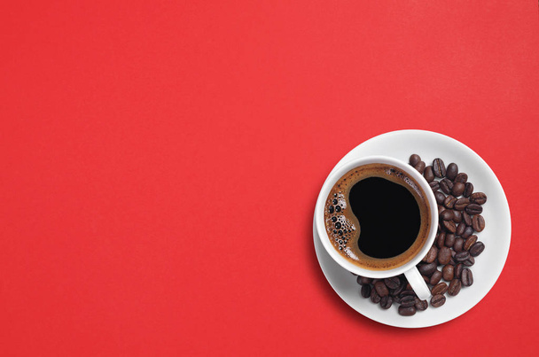 Vista superior de la taza de café y frijoles sobre un fondo rojo con espacio para copiar
 - Foto, Imagen