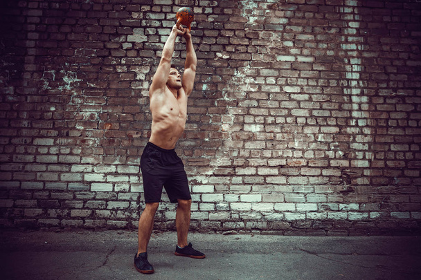 Athletic man working out with a kettlebell. Strength and motivation - Φωτογραφία, εικόνα
