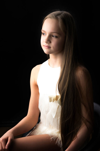 Beautiful teenage girl, studio photo. The concept of fashion and style. On a black background. - Valokuva, kuva