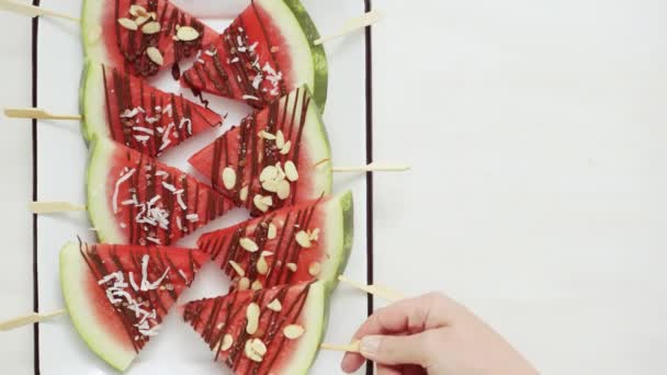 Stap voor stap. Watermeloen wiggen gegarneerd met chocolade en zee zout op de stick op het bakken blad. - Video