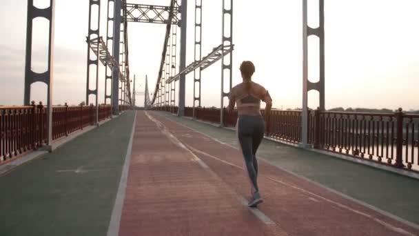 Lekkoatletka na treningu rano na most - Materiał filmowy, wideo