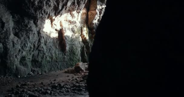 Skupina mladých speleologů v přilbách v temné jeskyni - Záběry, video