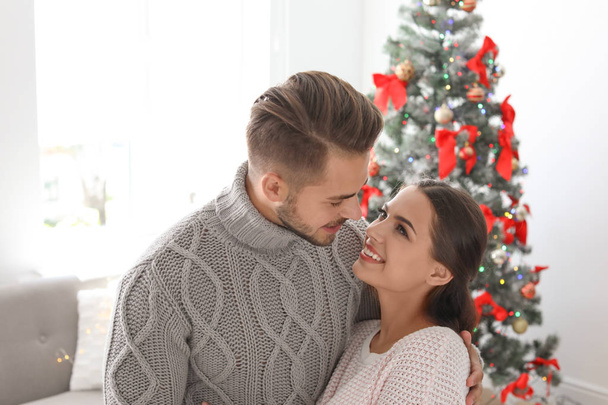 Happy young couple celebrating Christmas at home - Foto, afbeelding