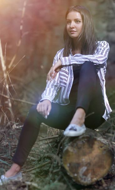 beautiful young woman sitting on a log - Foto, Bild