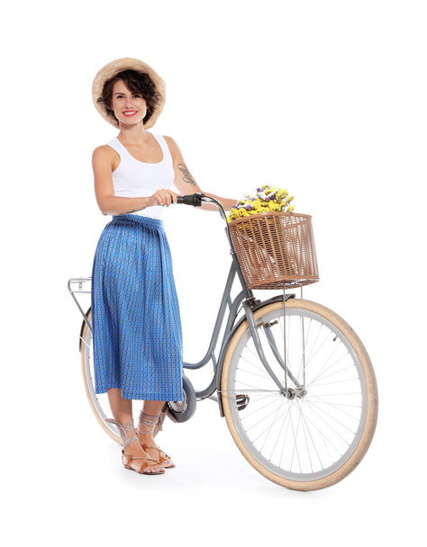 Portrait of beautiful young woman with bicycle on white background - Zdjęcie, obraz