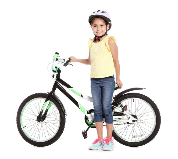 Portrait of cute little girl with bicycle on white background - Foto, Imagen