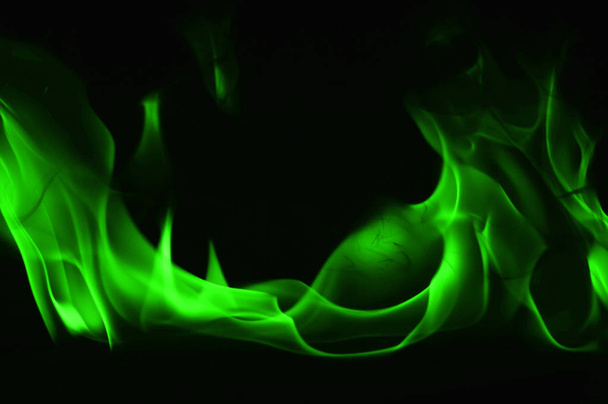 Красиве вогняне зелене полум'я на чорному тлі
. - Фото, зображення