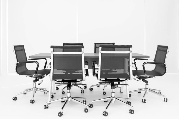 Ryhmä mustia tuoleja on pöytä valkoisessa kokoushuoneessa, moderni kokoustila uudessa toimistossa, kukaan sisällä
. - Valokuva, kuva