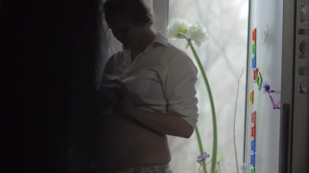 Smiling pregnant woman with mobile phone at home - Video