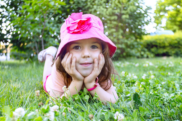little smiling girl on the green grass. children's holiday - Foto, Imagem