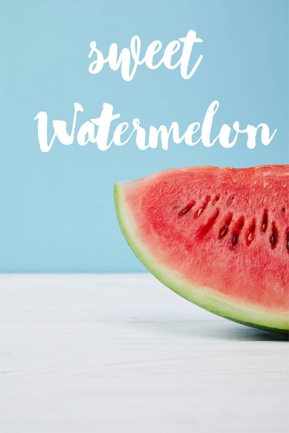 frische rote Wassermelonenscheibe auf weißer Oberfläche auf blauer, mit "süßer Wassermelone" Schriftzug - Foto, Bild