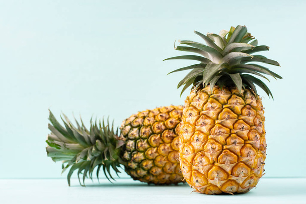 Ripe pineapple on green background, tropical fruit - Fotó, kép