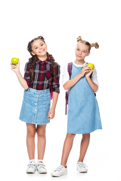 schoolkinderen holding appels en kijken naar camera geïsoleerd op wit - Foto, afbeelding