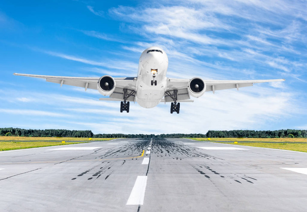 Passagierflugzeug landet bei klarem Wetter mit blauem Himmel auf Landebahn - Foto, Bild