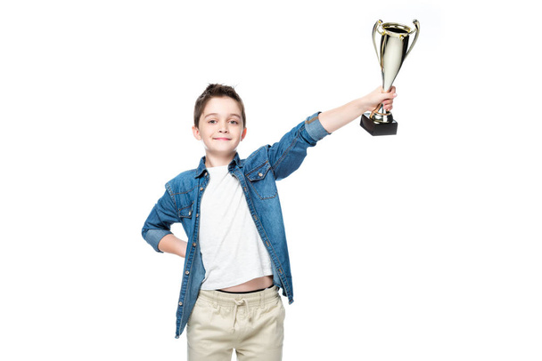 schoolboy showing winner cup isolated on white - Φωτογραφία, εικόνα