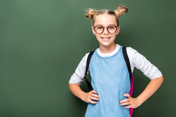 Lächelndes Schulkind mit Brille posiert in der Nähe der Tafel - Foto, Bild