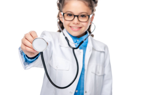 escolar disfrazado de médico mostrando estetoscopio aislado en blanco
 - Foto, Imagen