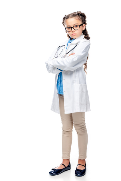 serious schoolchild in white coat standing with crossed arms isolated on white - Fotografie, Obrázek
