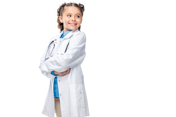 schoolchild in costume of doctor standing with crossed arms isolated on white - 写真・画像
