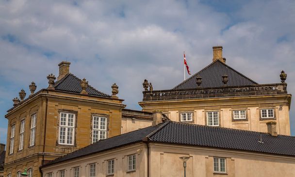 Το παλάτι Amalienborg στην Κοπεγχάγη, Δανία. Γύρω από την πλατεία των ανακτόρων με το άγαλμα του βασιλιά Frederik V από 1771, Κάστρο Αμάλιενμποργκ αποτελείται από τέσσερα όμοια κτίρια. - Φωτογραφία, εικόνα
