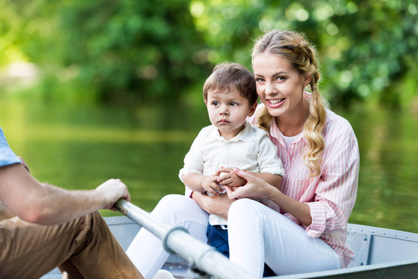 parents riding boat on lake with son at park - Foto, Imagem