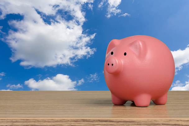 Pink piggy bank on blue sky background - Foto, immagini